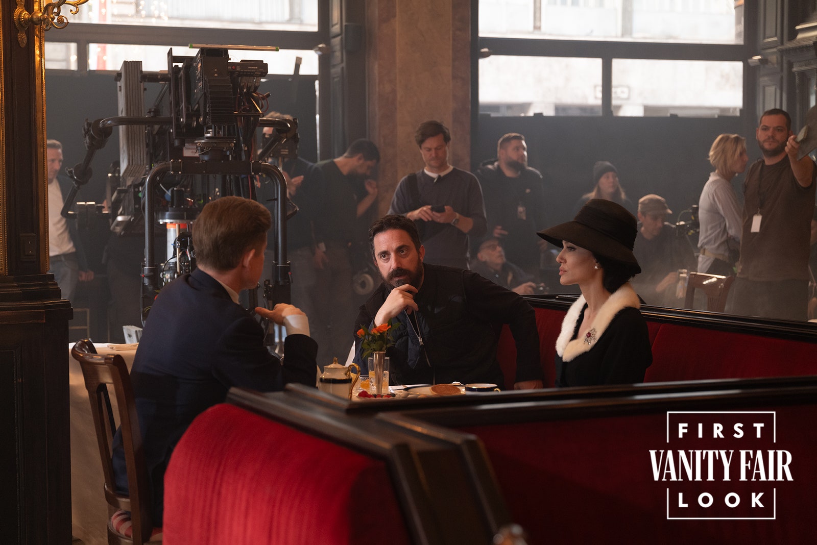 Image may contain Pablo Larraín Indoors Restaurant Pub Clothing Hat Adult Person Chair Furniture Cup and Table